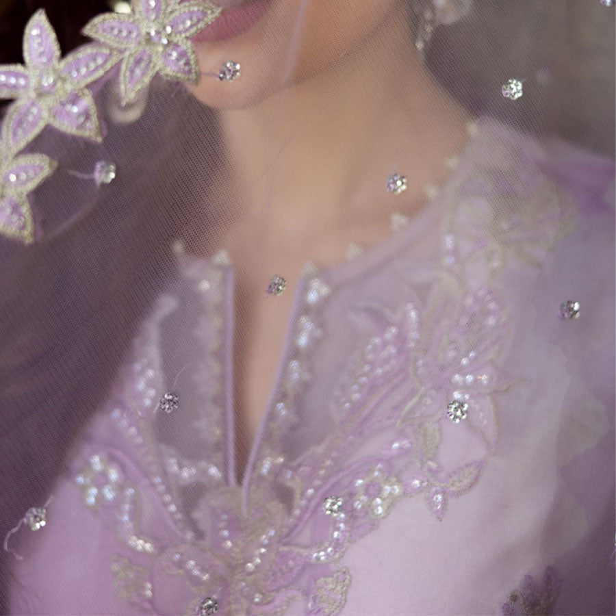 Charizma Festive Unstitched Collection 2025 – Two models wearing elegant embroidered Pakistani suits in pastel blue and golden yellow, featuring intricate handwork, sequins, and delicate embellishments, perfect for Eid celebrations and festive occasions.