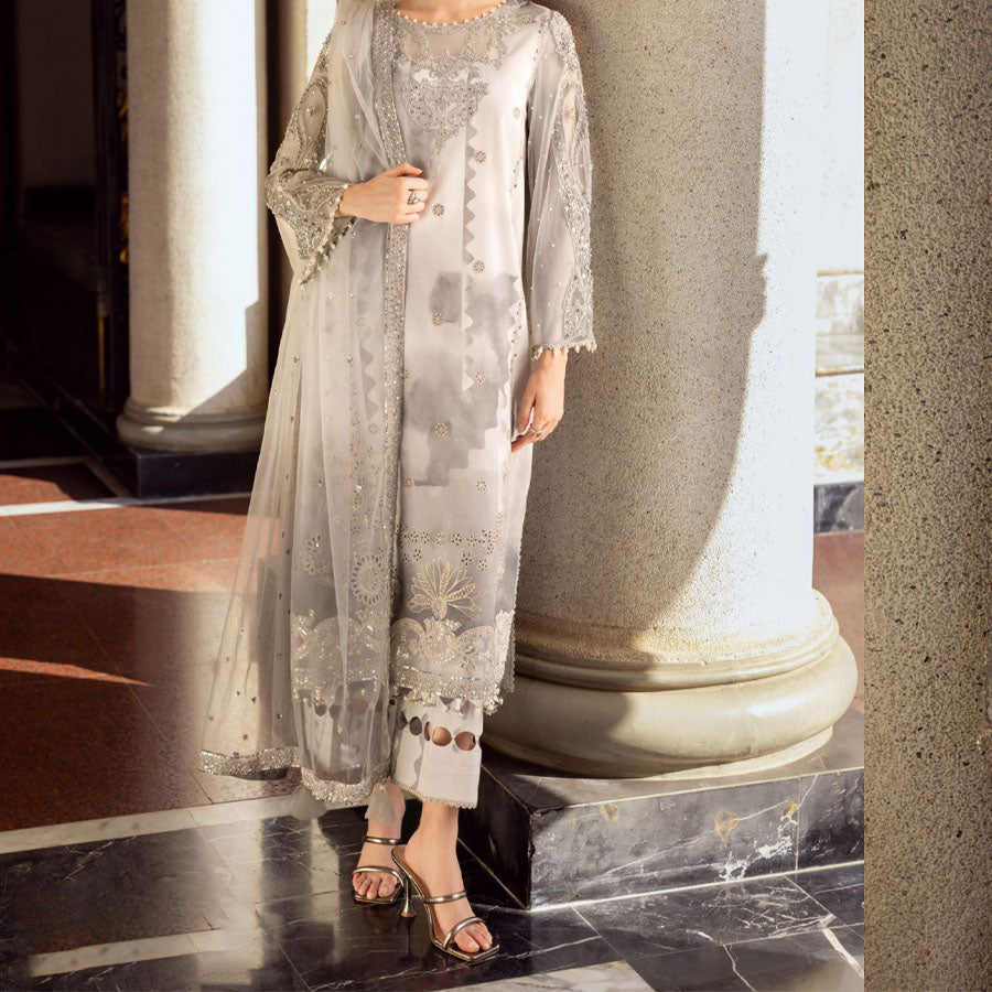 Charizma Festive Unstitched Collection 2025 – Two models wearing elegant embroidered Pakistani suits in pastel blue and golden yellow, featuring intricate handwork, sequins, and delicate embellishments, perfect for Eid celebrations and festive occasions.