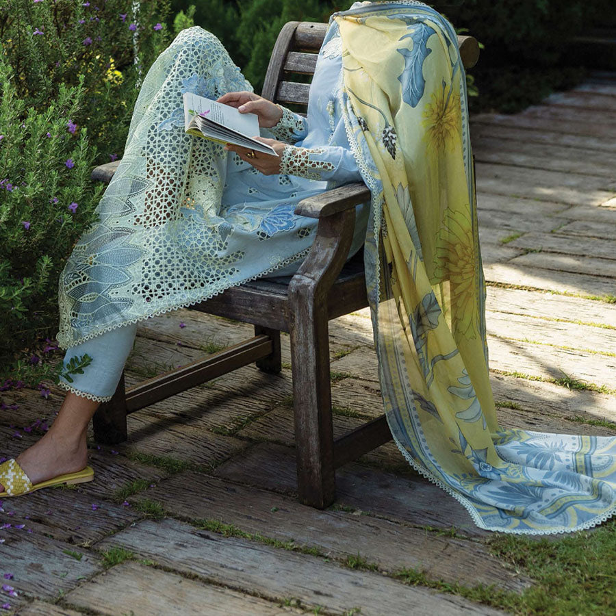 A model wearing a pastel embroidered lawn suit, featuring delicate floral patterns and a matching dupatta, ideal for summer occasions, sitting in a garden setting, showcasing traditional elegance and comfort, wearing a chickenkari embroidered dress.