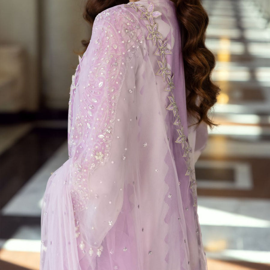 Charizma Festive Unstitched Collection 2025 – Two models wearing elegant embroidered Pakistani suits in pastel blue and golden yellow, featuring intricate handwork, sequins, and delicate embellishments, perfect for Eid celebrations and festive occasions.