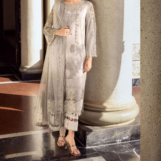 Charizma Festive Unstitched Collection 2025 – Two models wearing elegant embroidered Pakistani suits in pastel blue and golden yellow, featuring intricate handwork, sequins, and delicate embellishments, perfect for Eid celebrations and festive occasions.