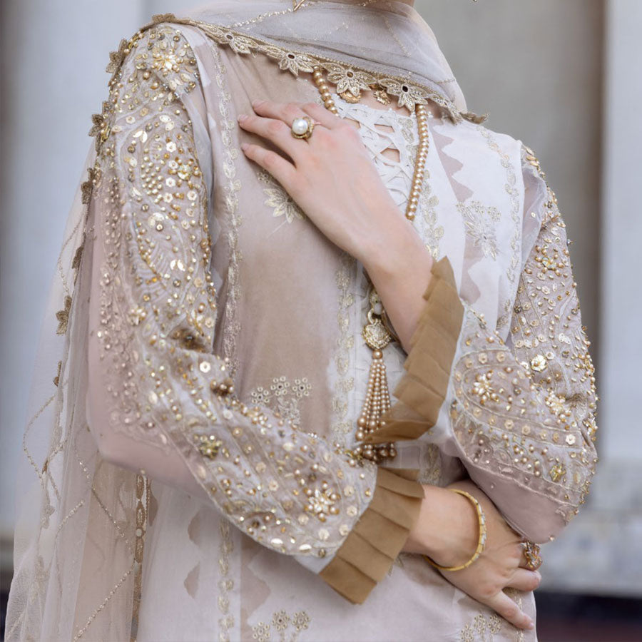 Charizma Festive Unstitched Collection 2025 – Two models wearing elegant embroidered Pakistani suits in pastel blue and golden yellow, featuring intricate handwork, sequins, and delicate embellishments, perfect for Eid celebrations and festive occasions.