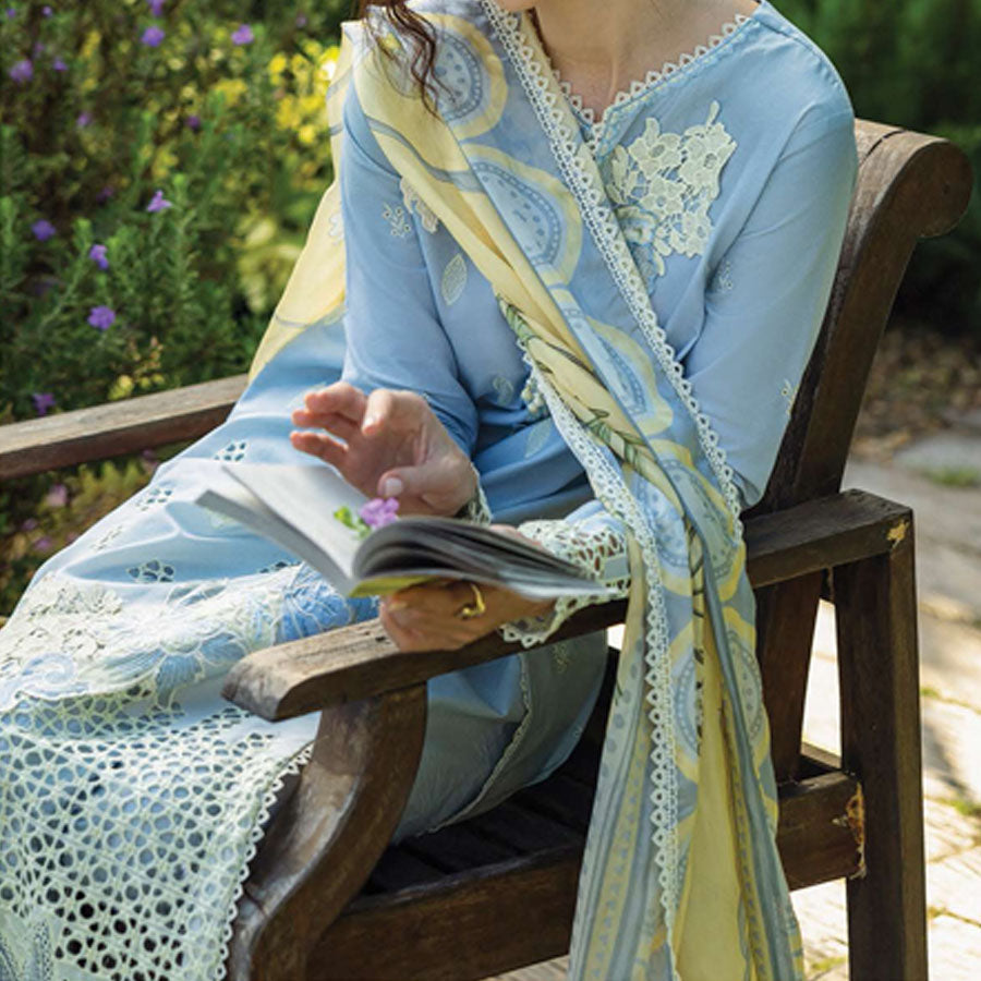 A model wearing a pastel embroidered lawn suit, featuring delicate floral patterns and a matching dupatta, ideal for summer occasions, sitting in a garden setting, showcasing traditional elegance and comfort, wearing a chickenkari embroidered dress.