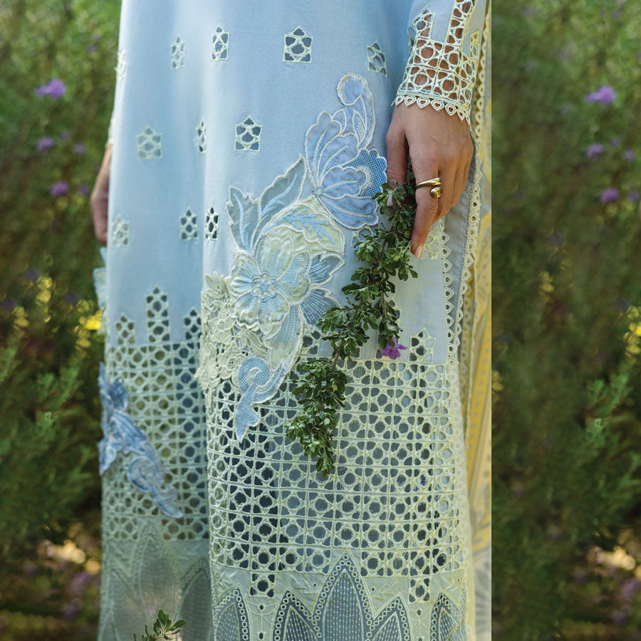 A model wearing a pastel embroidered lawn suit, featuring delicate floral patterns and a matching dupatta, ideal for summer occasions, sitting in a garden setting, showcasing traditional elegance and comfort, wearing a chickenkari embroidered dress.